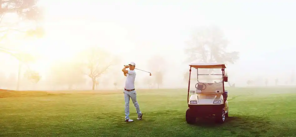 Electroquest for Golf Cart and Golf Trolley Batteries and accessories. Photo of a man playing golf next to a golf cart.