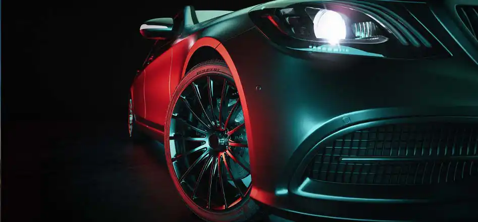 Car batteries store from Electroquest. For all your car battery needs. Photo of the side of a green sports car lit with a bright red light.
