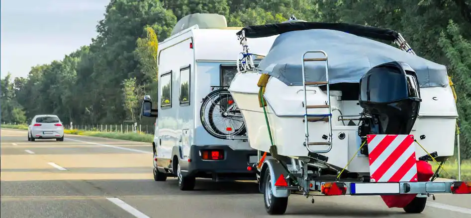 Leisure and marine batteries shop from Electroquest. Photo of a motorhome towing a speedboat.